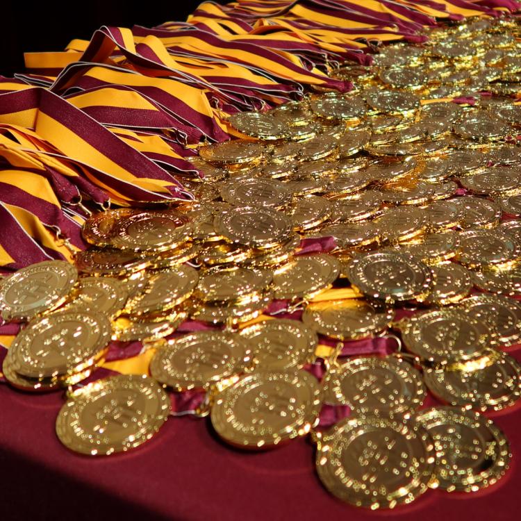 "FSU Honors Medallions on garnet tablecloth at Spring 2022 Medallion Ceremony in Ruby Diamond Concert Hall"