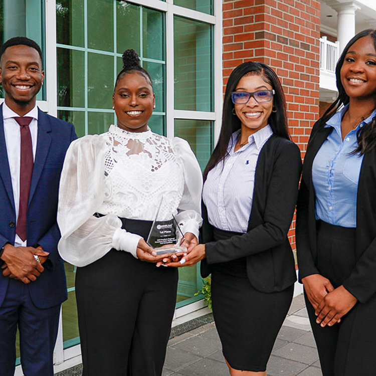 FSU College of Law's Black Students Association, Kayla Neal (former honors student - second from left, wearing a white blouse and black pants. She is holding the trophy."
