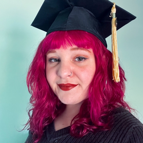 Image of Honors in the Major Student, Sabrina Linares. Bright red hair, wearing mortar board with tassle.
