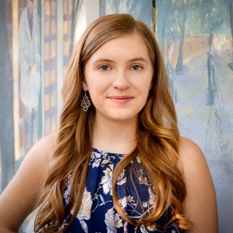 Image of Sarah Thrasher, Honors in the Major Student. Head shot of student, who has long blonde hair, dangle earrings, and sleeveless dark blue flowered dress.