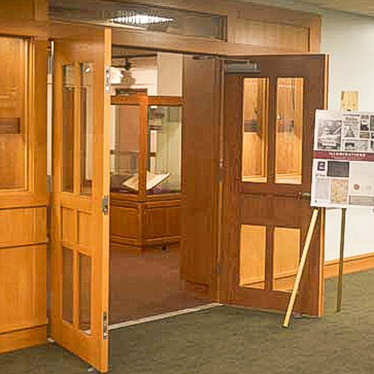 FSU Libraries Special Collections & Archives Entryway. Doors are open. The entry is all wooden paneling, including the doors. There is a standing easel at the entryway to the Special Collection & Archives Room.